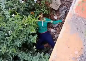 Mujer de lanza por segunda ocasión del puente en río Yaque en Montecristi