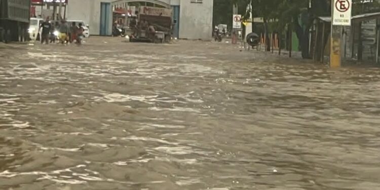 Inundación por lluvias impidió el tránsito por calle principal de Villa Vásquez